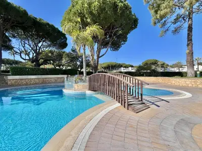 a swimming pool with a wooden fence and trees at Albufeira Balaia Golf Vilage 3 With Pool by Homing in Albufeira