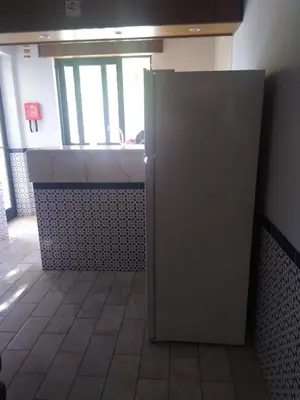 a large metal refrigerator in a room with a window at Melaya Private Rooms in Faro