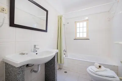 a bathroom with a sink and a toilet and a tub at Villa Nina in Albufeira