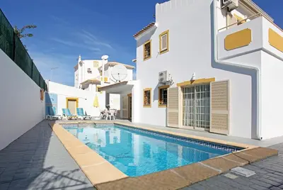 a villa with a swimming pool in front of a house at Villa Nina in Albufeira