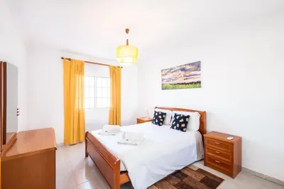 a bedroom with a bed and a dresser and a window at Sweet Home Arrifes in Albufeira