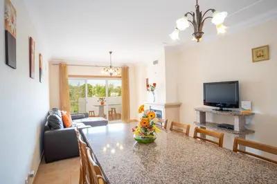 a living room with a table and a television at Thiago Holidays Apartment in Albufeira