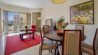 a living room with a table and chairs and a dining room at Greice Homes- 3 bed Luxury Apartment in Vilamoura in Quarteira