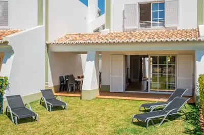 a patio with chairs and a table in a yard at Gale SunBeach Village - Jardins da Gale in Albufeira
