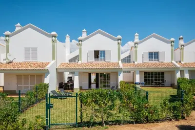 a large white house with a fence at Gale SunBeach Village - Jardins da Gale in Albufeira