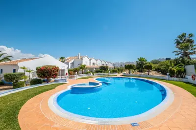a swimming pool in a yard with houses in the background at Gale SunBeach Village - Jardins da Gale in Albufeira