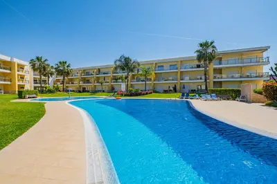 a large swimming pool in front of a building at Achard Marina Apartment in Albufeira