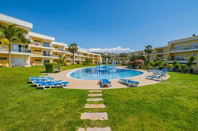 a swimming pool with lounge chairs and a resort at Achard Marina Apartment in Albufeira