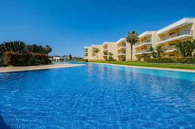 a large swimming pool in front of a building at Achard Marina Apartment in Albufeira