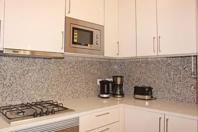 a kitchen with a stove and a microwave at Achard Marina Apartment in Albufeira