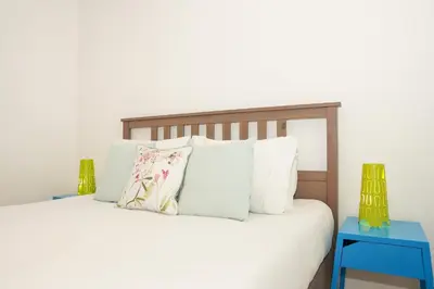 a bedroom with a white bed with two blue tables at Villa Catarina Ocean View in Albufeira