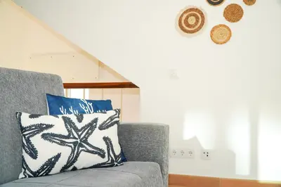 a gray couch with a blue and white pillow on it at Villa Catarina Ocean View in Albufeira