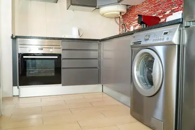 a kitchen with a washing machine and a stove at Villa Catarina Ocean View in Albufeira