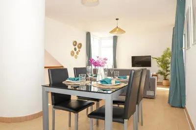 a dining room with a black table and chairs at Villa Catarina Ocean View in Albufeira