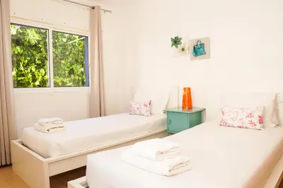 two beds in a room with a window at Villa Catarina Ocean View in Albufeira