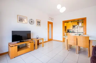 a kitchen with wooden cabinets and a table at Barracuda Oura Dream Apartment in Albufeira