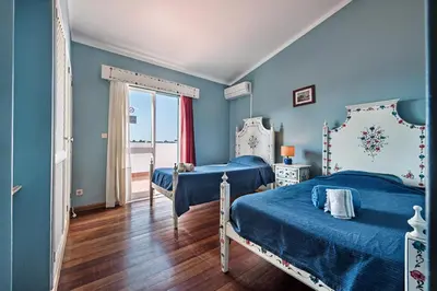 two beds in a room with blue walls at Villa Jonas in Albufeira
