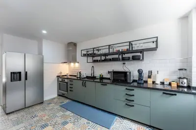 a kitchen with a stainless steel refrigerator at Malpique heated pool & Jacuzzi Guest House in Albufeira