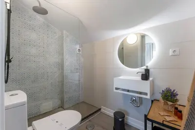 a bathroom with a toilet and a sink and a mirror at Malpique heated pool & Jacuzzi Guest House in Albufeira