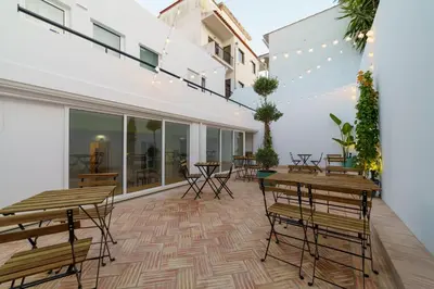 an outdoor patio with wooden tables and chairs at Atlantic Bliss in Albufeira
