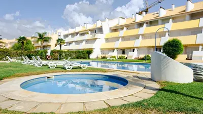 a swimming pool in front of a large building at Carpe Diem Vilamoura By Dualhotels in Vilamoura