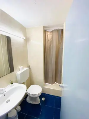 a bathroom with a white toilet and a sink at Casa da Oura in Albufeira
