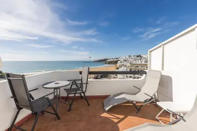 a balcony with chairs and a table and the ocean at Apartamentos Pescadores in Albufeira