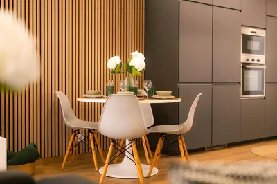 a kitchen with a table with white chairs and a refrigerator at Carmo House in Faro
