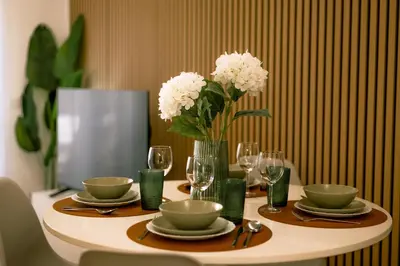 a table with plates and glasses and a vase with flowers at Carmo House in Faro