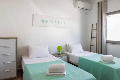 a bedroom with two beds with green sheets at Villa Namora in Albufeira