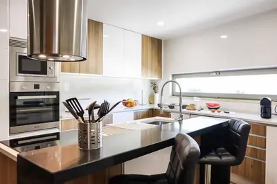 a kitchen with a counter with a sink and a stove at Villa Namora in Albufeira
