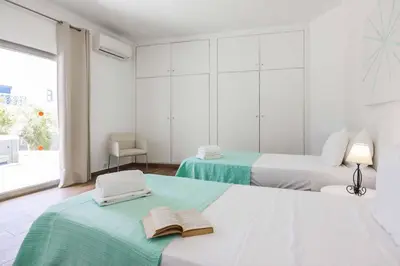 two beds in a white room with towels on them at Villa Namora in Albufeira