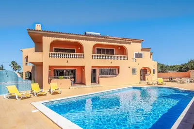 a villa with a swimming pool in front of a house at Casa Pluma in Albufeira