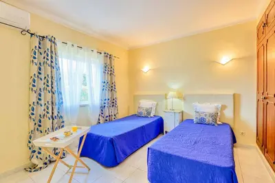 a bedroom with two beds and a table and a window at Villa Jeanic in Galé