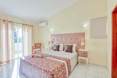 a bedroom with a large bed and a chair at Villa Jeanic in Galé