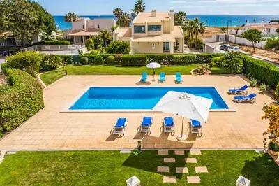 an overhead view of a swimming pool with chairs and umbrellas at Villa Luz Figueiras in Galé