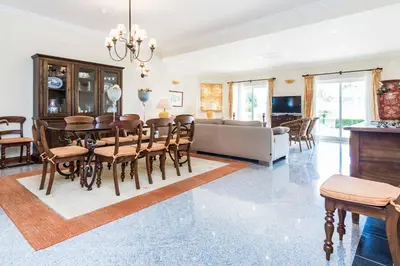 a dining room and living room with a table and chairs at Villa Luz Figueiras in Galé