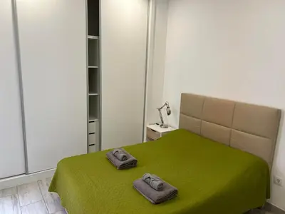 a bedroom with a green bed with two slippers on it at CASA CANELAS in Faro