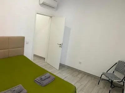 a bedroom with a green bed and a chair at CASA CANELAS in Faro