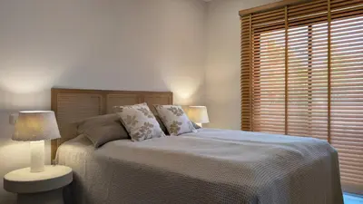 a bedroom with a bed with two lamps and a window at Villa Pinetree Seaside, Albufeira in Albufeira