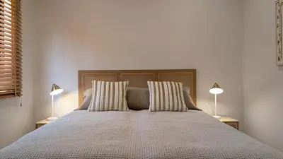 a bedroom with a large bed with two lamps at Villa Pinetree Seaside, Albufeira in Albufeira