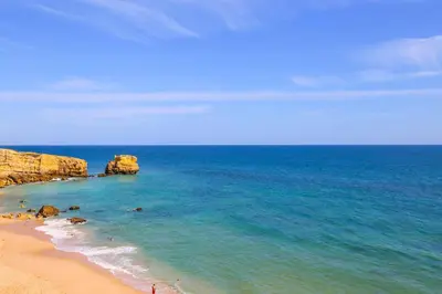 a view of a beach with rocks and the ocean at Casa Barreto in Albufeira