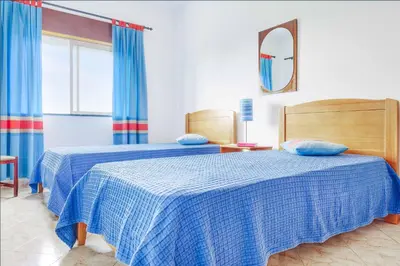 a bedroom with two beds and a mirror at Casa Barreto in Albufeira
