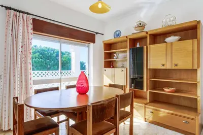 a kitchen with a table and chairs and a window at Casa Barreto in Albufeira