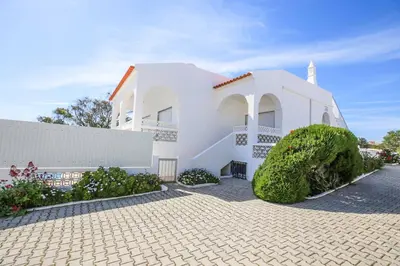 a white house with a white fence and bushes at Casa Barreto in Albufeira