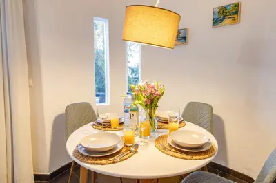 a white dining room table with chairs and a light fixture at Seaside Retreat with Pool, AC, and Fast Wi-Fi in Albufeira
