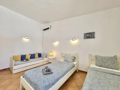 a bedroom with two beds and a couch at Albufeira Quinta da Balaia Charming by Homing in Albufeira