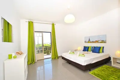 a bedroom with a large bed with green curtains at Apartment Ipanema 1 by Algarve Vacation in Albufeira