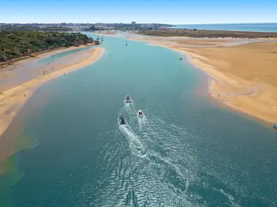 two boats in the water next to a beach at Apartment Ipanema 1 by Algarve Vacation in Albufeira