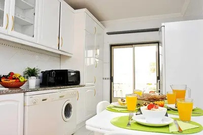 a white kitchen with a table with food and orange juice at Apartment Ipanema 2 by Algarve Vacation in Albufeira